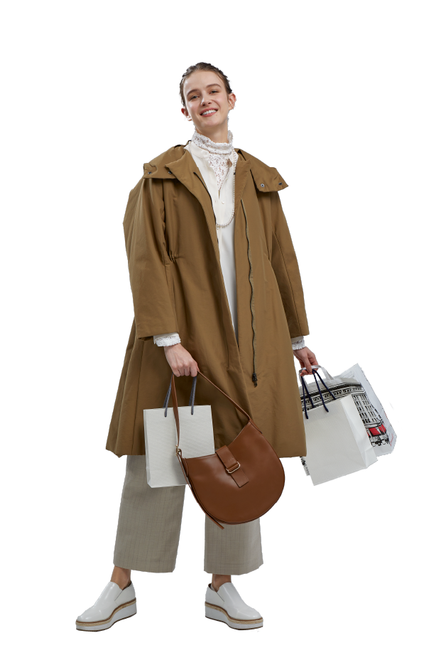 茶色いコートを着た、紙袋をたくさん持った女性の写真