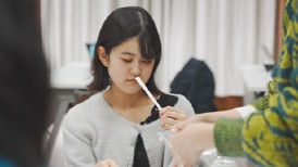 視覚障害者の女性が香りを確認している様子。