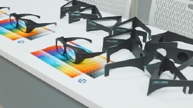 画像:テーブルに色弱模擬フィルタ「バリアントール」や「ロービジョン体験キット」が並べられている様子。 画像おわり