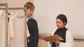 画像:売場をイメージした会場で、視覚障がい者の男性にバイヤーがインタビューしている。 画像おわり