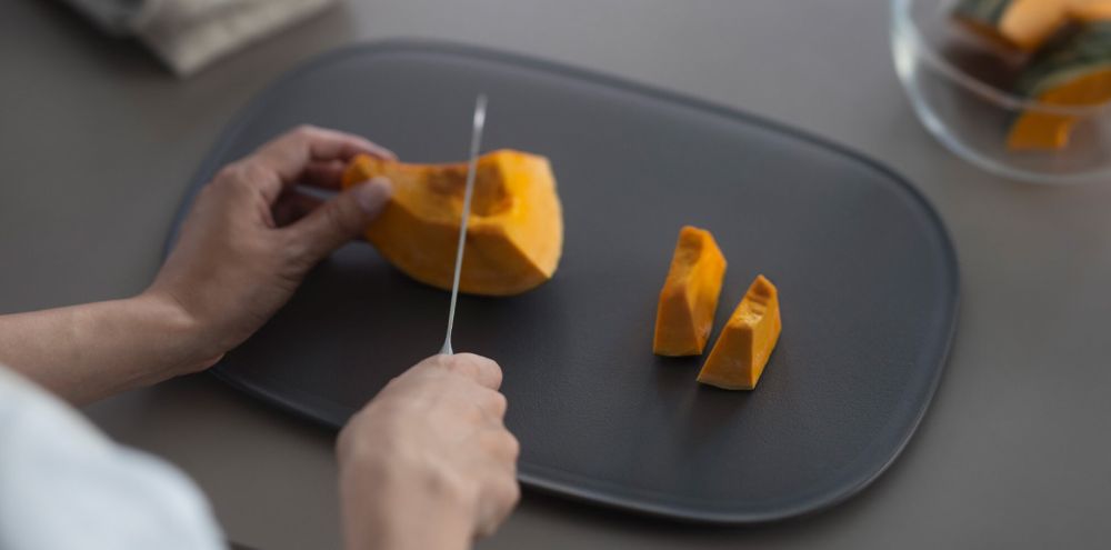 まな板の上でカボチャを切っている写真