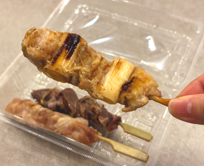 焼き鳥のももねぎ串を持っている写真