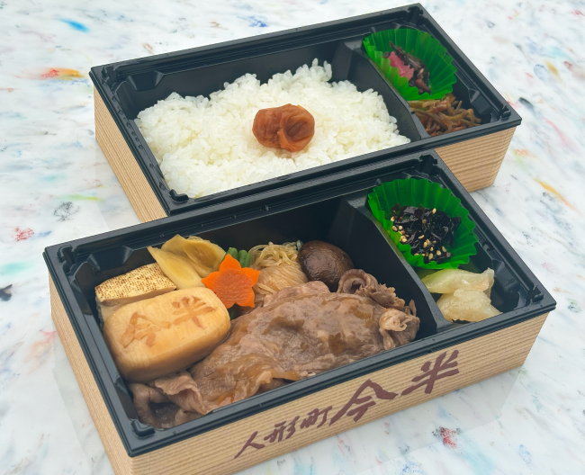 すき焼きとごはんがそれぞれ別の容器に入った2段弁当の画像