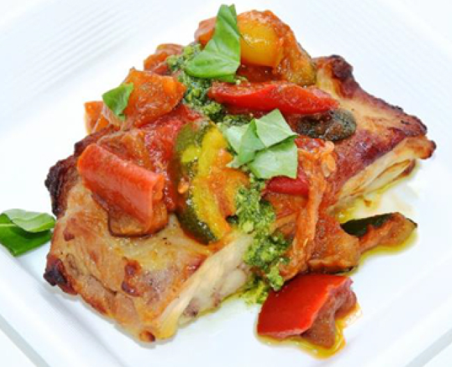 香ばしく焼いた鶏肉にパプリカなどを煮込んだソースがトッピングされたイメージの写真