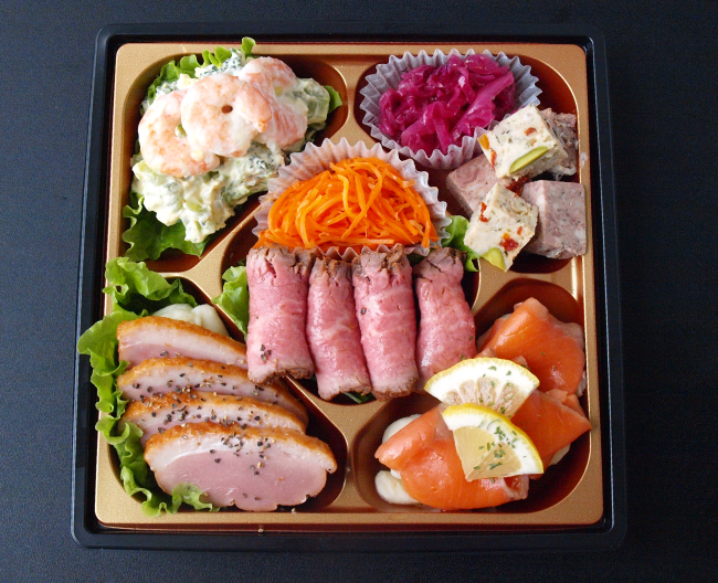 スモークサーモンや合鴨のスモーク、サラダなどを盛り合わせた折詰の写真