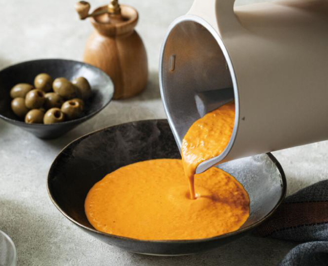 自動調理で作ったポタージュスープを器に注いでいる様子の写真