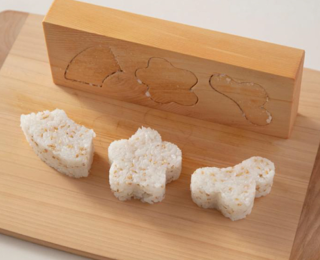 木製の押し型で松・竹・梅の形に型抜きした、ごま入りご飯の写真