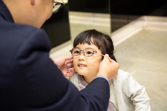 オグラ眼鏡店こどもメガネ アンファンのスタッフがメガネをお子様にかけている様子