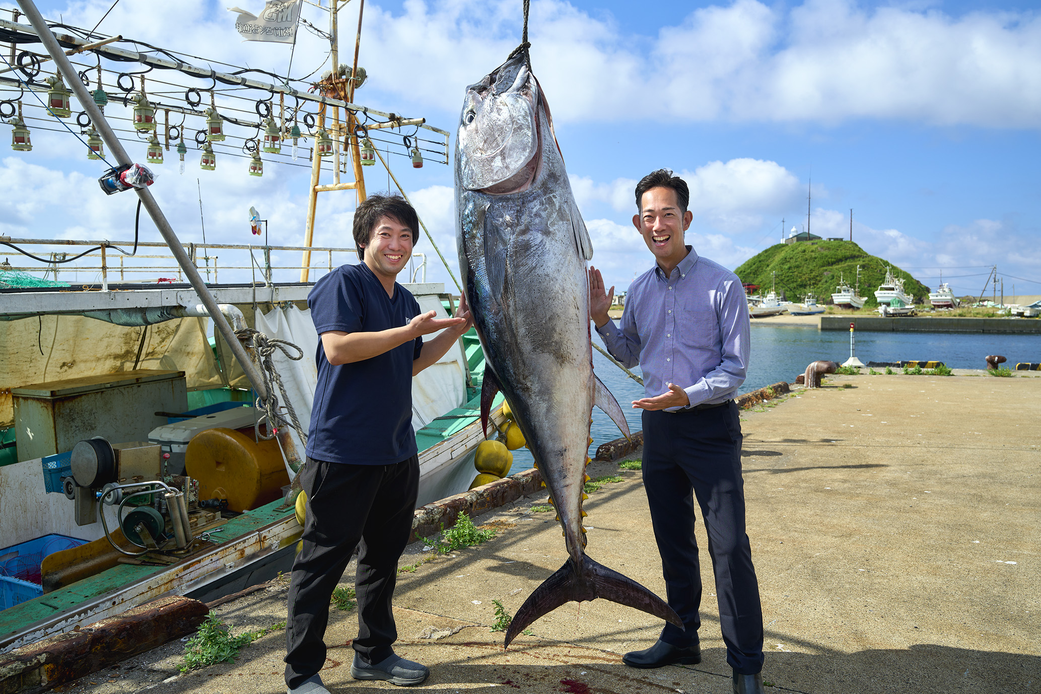 捕獲したまぐろと一緒に写真を撮る古川バイヤー