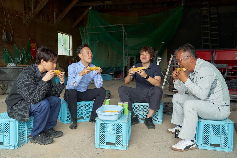 収穫したてのとうきびをみんなで食べるシーン