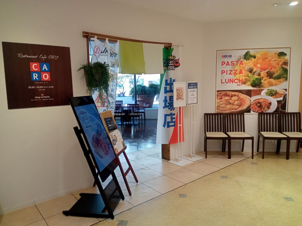 料理写真のポスターが貼ってあるカーロ入口の写真