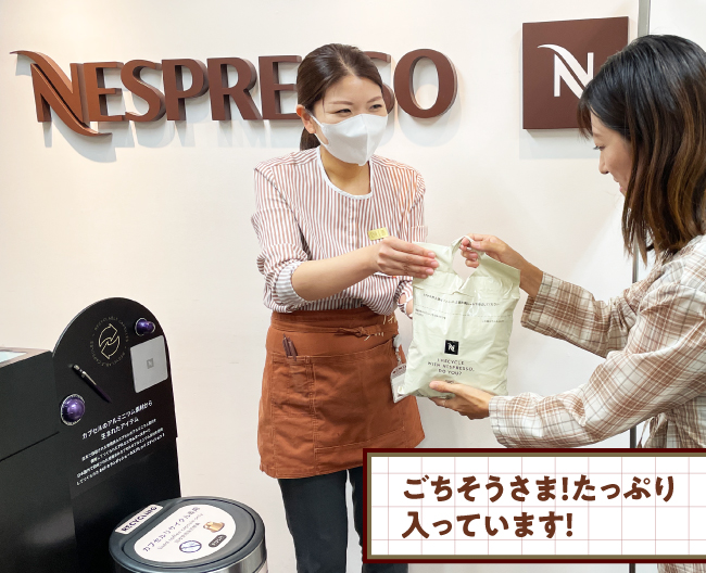 大野さんがネスプレッソブティックの店長に、返却用のリサイクルバッグを渡す写真