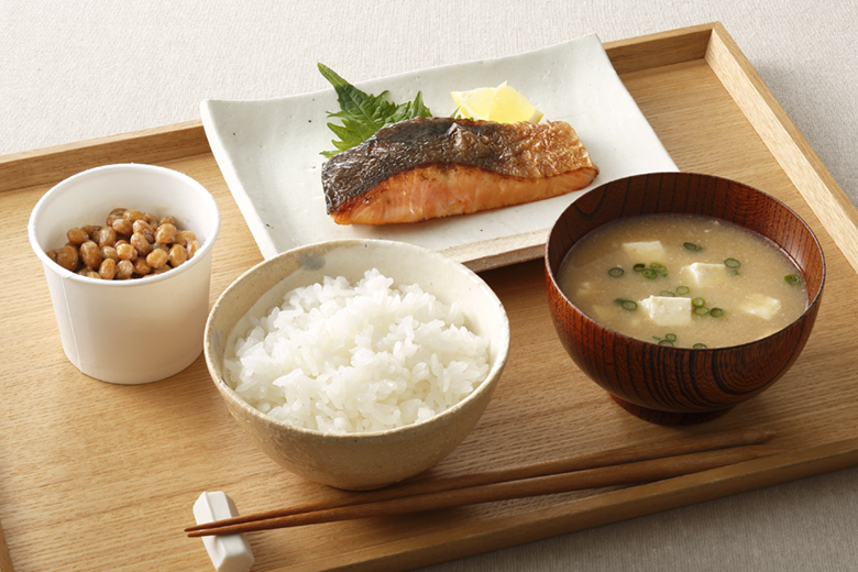 ごはんとお味噌汁に焼鮭と納豆が並ぶ和食の朝食の様子