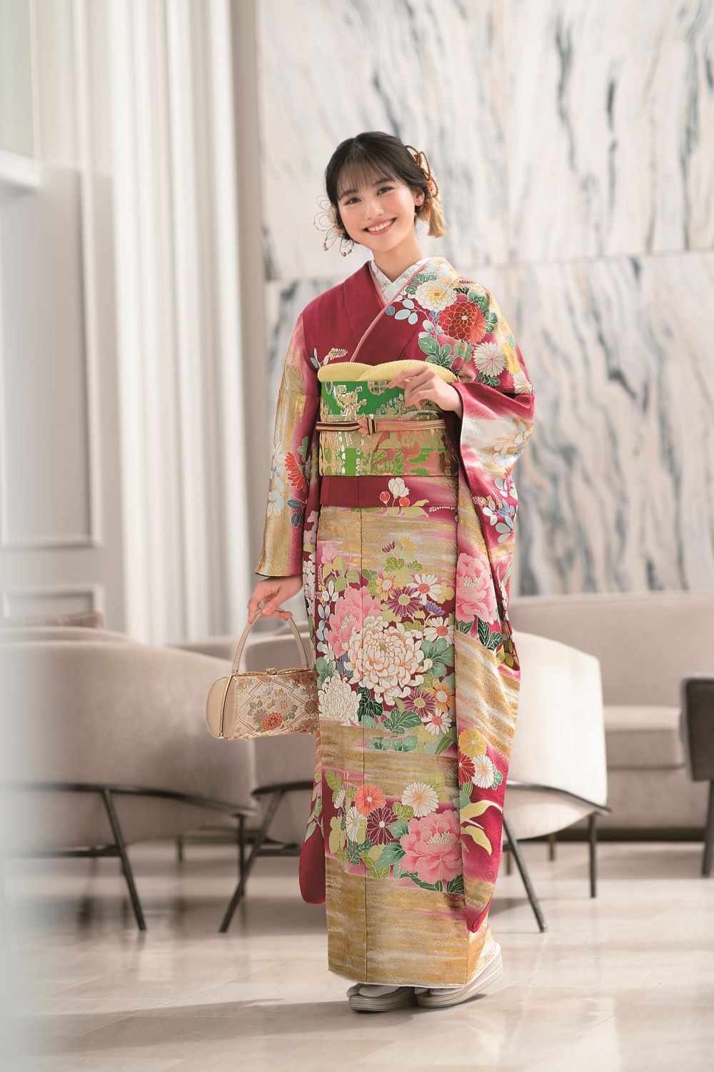 赤地の振袖に緑の帯を着用したモデルの写真