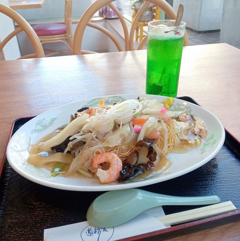 皿うどんとクリームソーダがトレーにのった写真