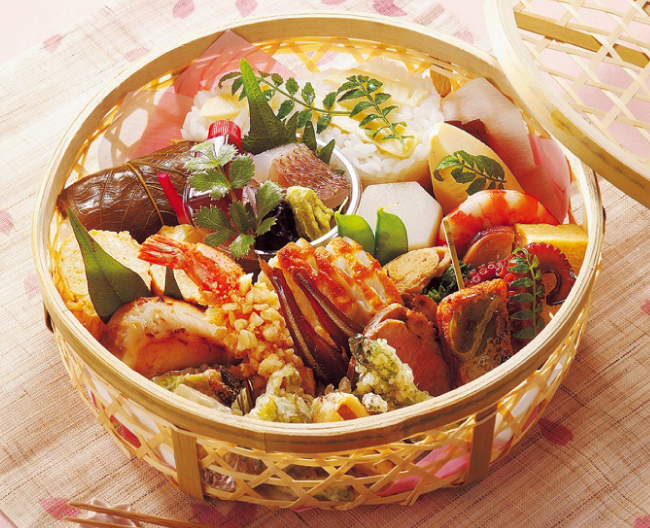 ［三友居］の選りすぐりの旬の素材を、彩り豊かに詰め合わせた竹籠弁当