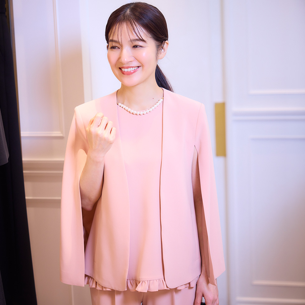 ブラウスとジャケットを着てほほ笑む女性